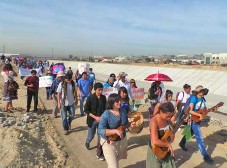 People marching along canal in Tijuana